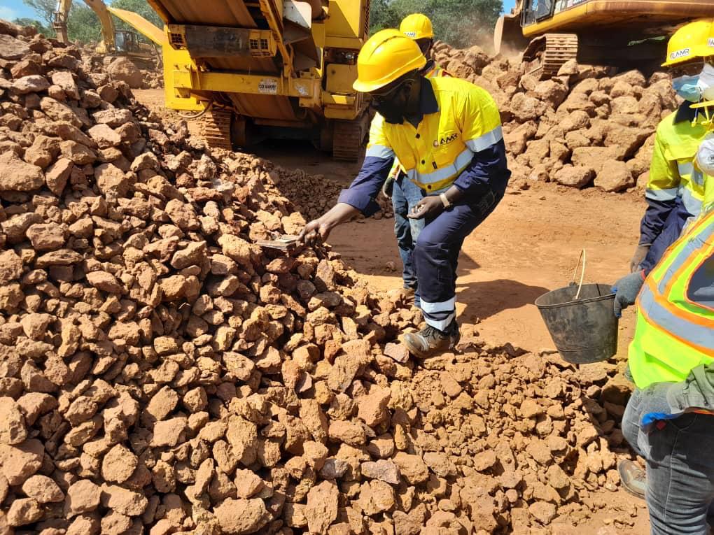 Worker sorting rocks at a construction site.